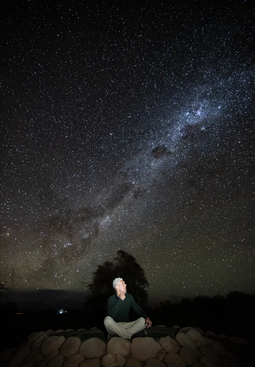 Hombre mayor contemplando el cielo estrellado de Atacama en silencio